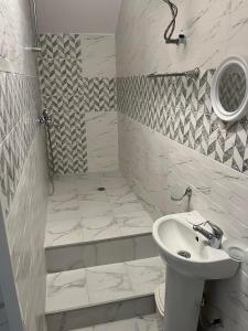 La salle de bains blanche est pourvue d'une douche et d'un lavabo. dans l'établissement Къща за гости "Холидей - Луковит", à Lukovit