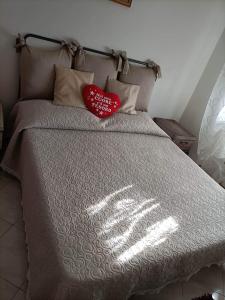 a bed with two red heart pillows on it at Wanderful room in Cinquale