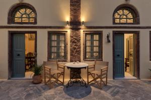 Un patio con una mesa y sillas en un edificio. en Villa Historia, en Oia