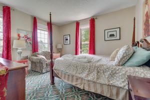 a bedroom with a bed and a chair and windows at Spacious Victorian Home quarter Mi to Holiday Valley! in Ellicottville