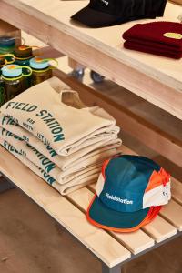 a pile of hats and a baseball cap on a shelf at Field Station Joshua Tree in Yucca Valley
