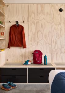 a bedroom with a bench with a red jacket and shoes at Field Station Joshua Tree in Yucca Valley