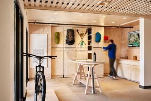 a woman standing in a kitchen next to a bike at Field Station Joshua Tree in Yucca Valley