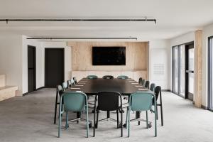 a conference room with a black table and chairs at Field Station Joshua Tree in Yucca Valley