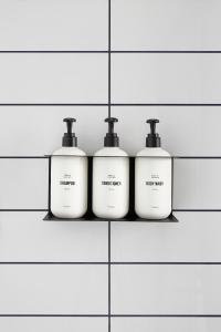 a row of three soap bottles on a wall at Field Station Joshua Tree in Yucca Valley