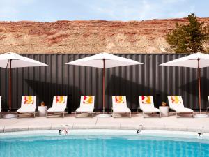 a group of chairs and umbrellas next to a pool at Field Station Joshua Tree in Yucca Valley