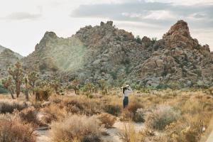 a person standing in a field in front of a mountain at Field Station Joshua Tree in Yucca Valley