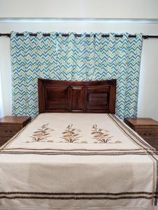 a bed with a wooden headboard in a bedroom at Espacioso apartamento en Puerto Plata in San Felipe de Puerto Plata