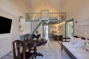 Una sala de estar con una mesa y una escalera. en Villa Historia, en Oia