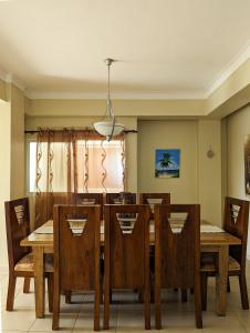 comedor con mesa de madera y sillas en Espacioso apartamento en Puerto Plata en San Felipe de Puerto Plata