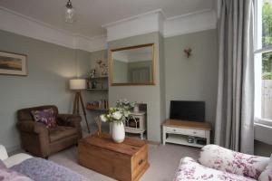 a living room with a vase of flowers on a coffee table at Artisan Cottage - Bath in Bath