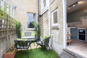 małe patio z krzesłami i stołem w budynku w obiekcie Artisan Cottage - Bath w mieście Bath