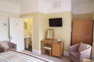 a bedroom with a bed and a mirror and a sink at The Baytree in Torquay