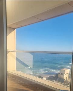 uma vista para o oceano a partir de uma janela aberta em תמר על הים em Bat Yam