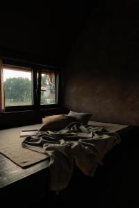un letto in una camera buia con finestra di Michelberger Farm a Vetschau