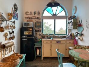 a kitchen with a black refrigerator and a table at Zehava's Zimmer in Ein Gedi