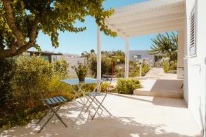 a white patio with a table and chairs on it at Iconica Luxury Suites in Alberobello