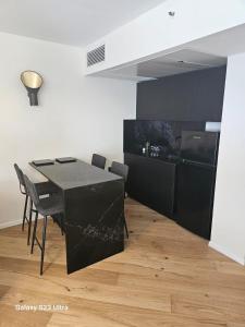 a dining room with a black table and chairs at תמר על הים in Bat Yam