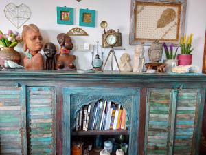 a wooden cabinet with a bunch of items on it at Zehava's Zimmer in Ein Gedi