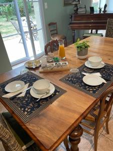 a wooden table with plates and utensils on it at Ferme de Maillezais in LʼHoumeau