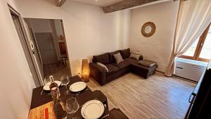 uma sala de estar com um sofá e uma mesa em Appartement T2 centre village em Cucuron
