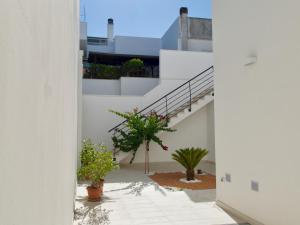 ガラティーナにあるNewly Renovated-Holiday house with large gardenの階段と鉢植えのある建物の廊下からの眺め