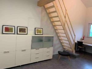 una sala de estar con un gran armario blanco y una escalera en Moderne Maisonettewohnung/2 Zimmer/Küche/Bad #1, en Markt Schwaben