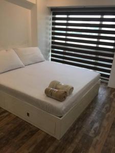 Una cama blanca grande con una toalla. en Renovated 2br 2tb Wifi/Netflix very near Mall QC, en Manila