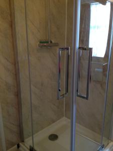 a shower with a glass door in a bathroom at Ord Arms Hotel in Muir of Ord