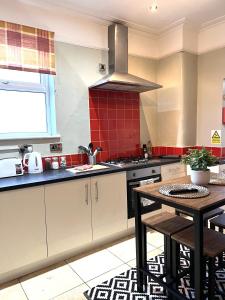 a kitchen with a table and a stove top oven at Russell House in Liverpool