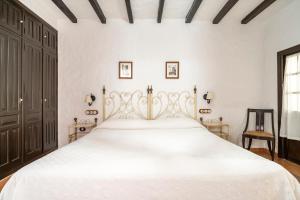 a bedroom with a large white bed in a room at Cortijo Huerta Dorotea in Prado del Rey +25 photos