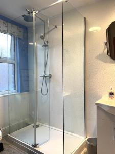 a shower with a glass door in a bathroom at Russell House in Liverpool