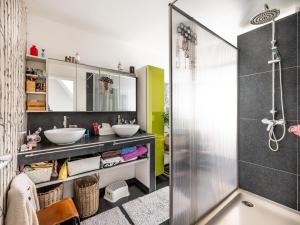 a bathroom with two sinks and a shower at Casa Julie in De Panne