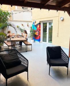 dwoje osób siedzących przy stole na patio w obiekcie Sant Jordi Hostels Sagrada Familia w Barcelonie