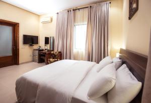 a bedroom with a large bed with white pillows at Rushmore - Premier 1 Room in Lagos