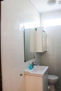 a bathroom with a sink and a toilet and a mirror at Okira beach house in Aguda