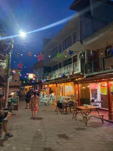 a group of people walking down a street at night at Hotel del Callejón in Zihuatanejo