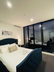um quarto com uma cama grande e uma janela grande em Free Parking-Luxurious & Spacious Skyline view Apt em Melbourne