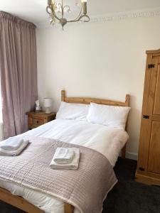 a bedroom with a bed with two towels on it at Arrandale Lodge in Norwich