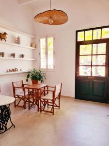 a dining room with a table and chairs and a green door at Waki Conscious Hotel in Ciutadella