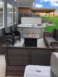 a patio with a grill and chairs and a hot tub at Bridges Bay Vacation Cabin 152 in Arnolds Park