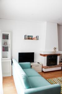 a living room with a blue couch and a fireplace at Okira beach house in Aguda