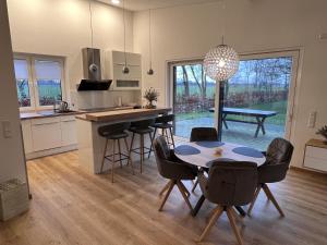 a kitchen and dining room with a table and chairs at Ferienhaus Hallix in Sande