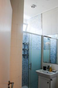 a bathroom with a glass shower and a sink at Okira beach house in Aguda