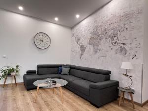 a living room with a couch and a clock on a wall at Ferienhaus Hallix in Sande