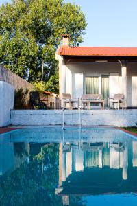 a swimming pool with chairs and a house in the background at Okira beach house in Aguda