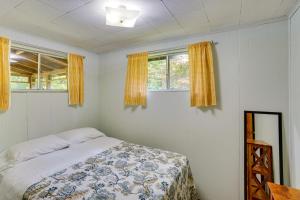 1 dormitorio con 1 cama y 2 ventanas en Cozy Becket Cottage Escape with Lake Access!, en Becket