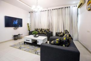 a living room with two couches and a tv at Rushmore - Premier 2 Room in Lagos