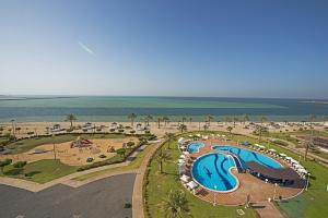 an aerial view of a resort with a swimming pool and the beach at Mirfa Hotel in Al Marfaʼ