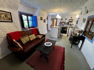 a living room with a couch and a table and a kitchen at Cuevas La Veranda in Orce